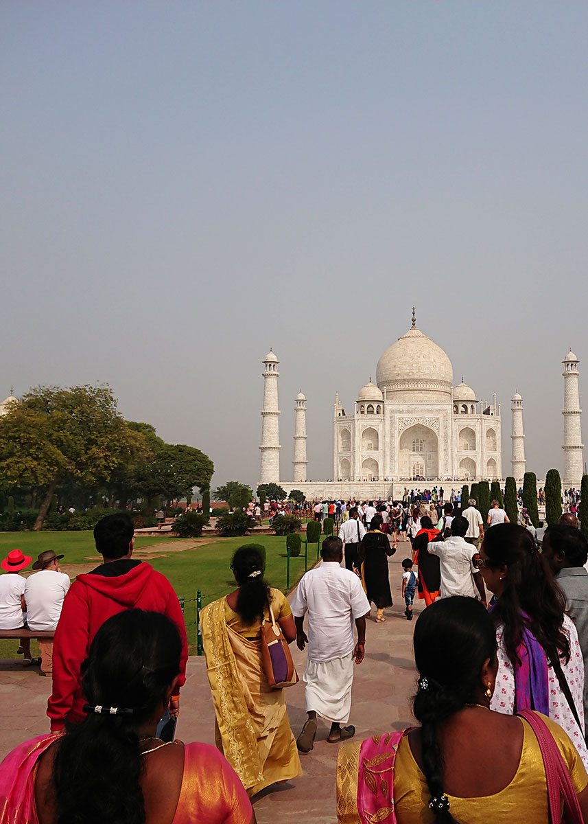 A large crowd is heading toward the marble monument of the Taj Mahal in Agra, India.