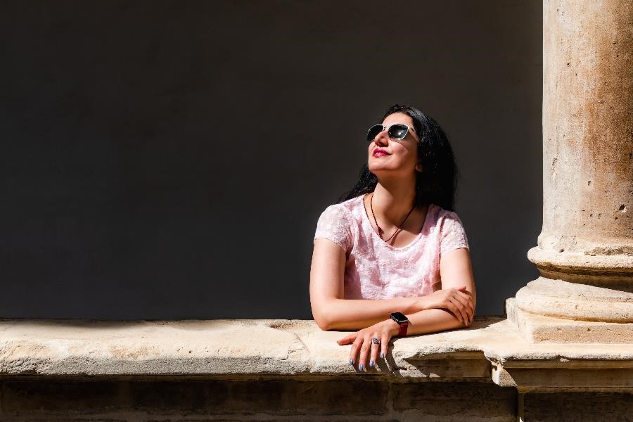 A beautiful Persian woman standing in the sunlight in the courtyard of the church of Santa Maria in Mallorca