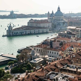 A distant view of Basilica Santa Maria della Salute, visible among the orange Venetian rooftops