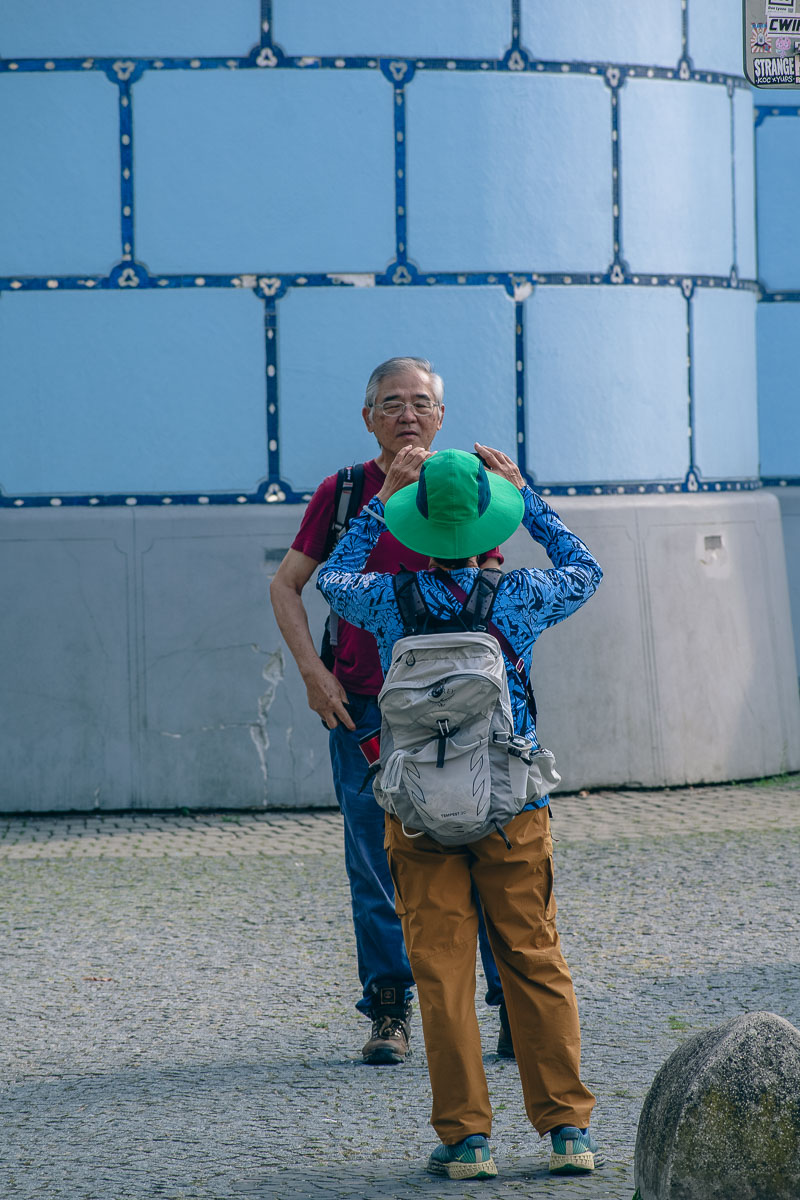 Two East Asian tourists taking photos in front of the Blue Church in Bratislava