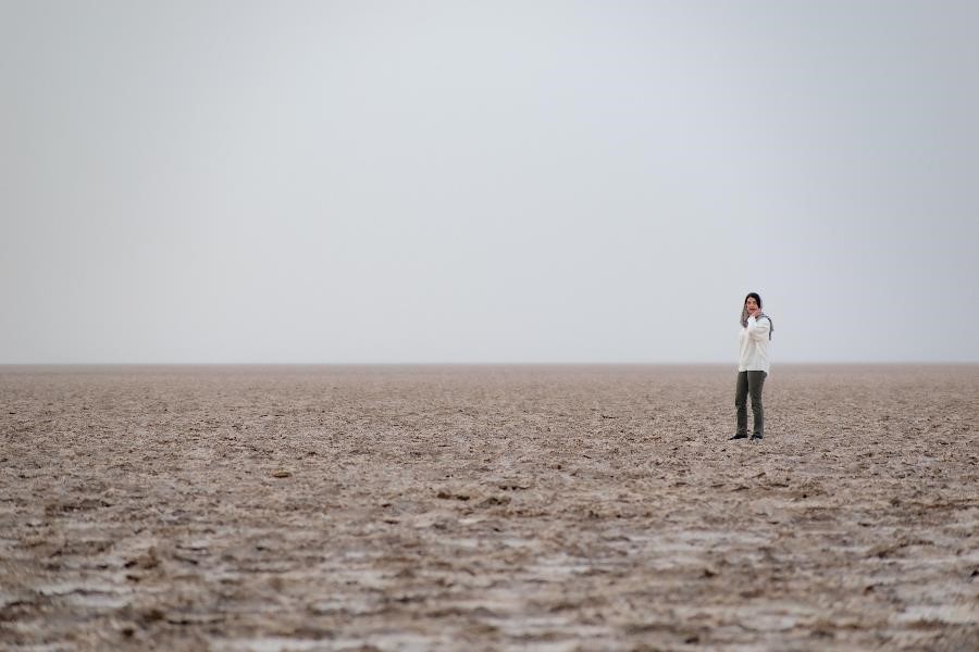 A Persian woman in the vastness of the salt lake in the central desert of Iran