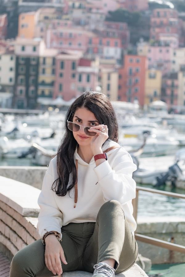 A beautiful woman with long black hair sitting in the port of Lerici near La Spezia in Italy