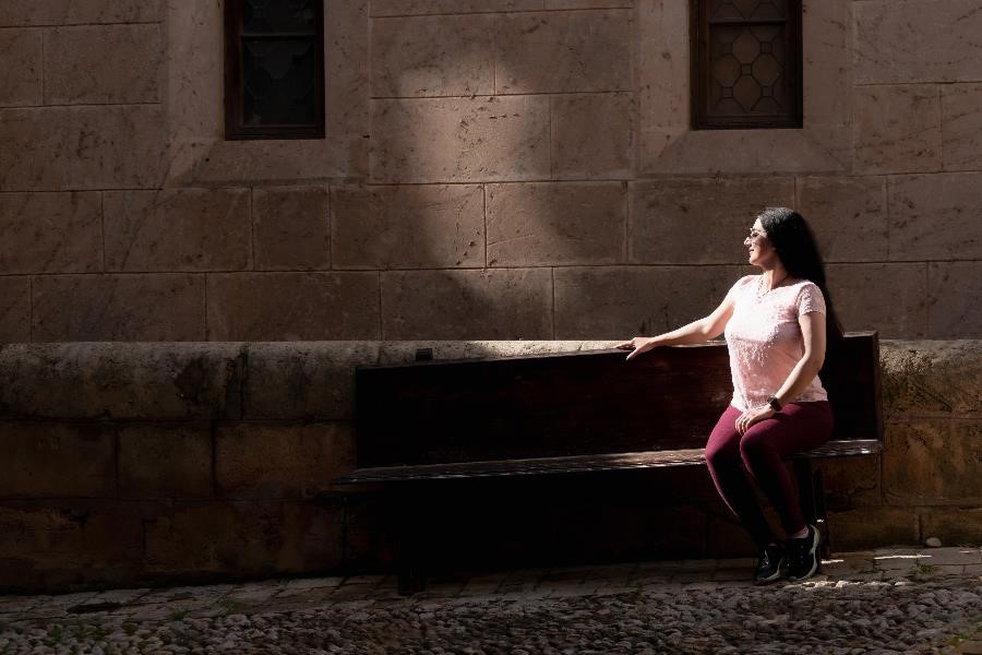 A Persian woman sitting on a stone bench in Puebla Espanyol, Majorca