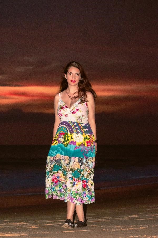 A Persian woman walking in a beautiful sunset on the coast of the Indian Ocean in Sri Lanka