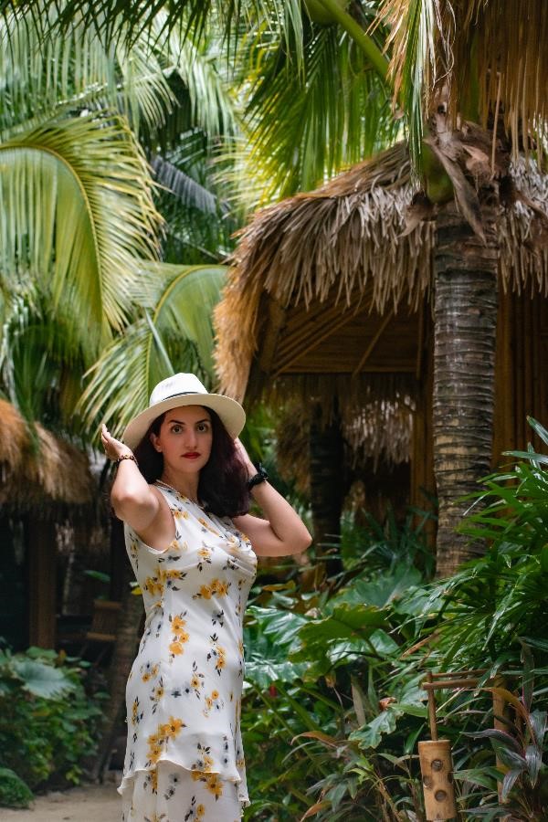 A beautiful woman with a white hat in the middle of a tropical forest in Thailand