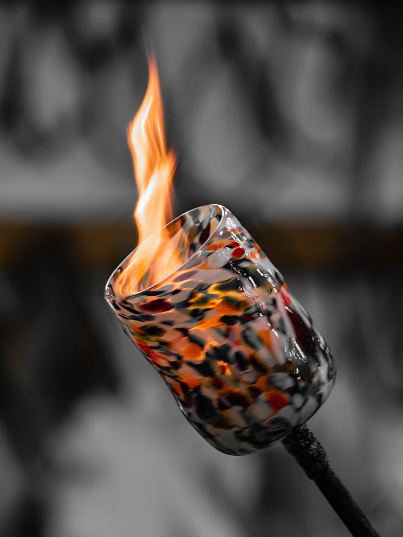 A flame inside a hot glass at a glassblowing workshop in Murano, Italy