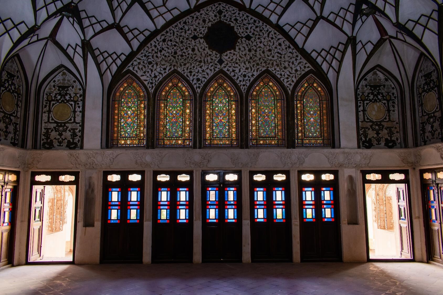 The archway, plasterwork, and mirrors all contribute to the dazzling display, but it is the stained glass that truly captivates the attention.