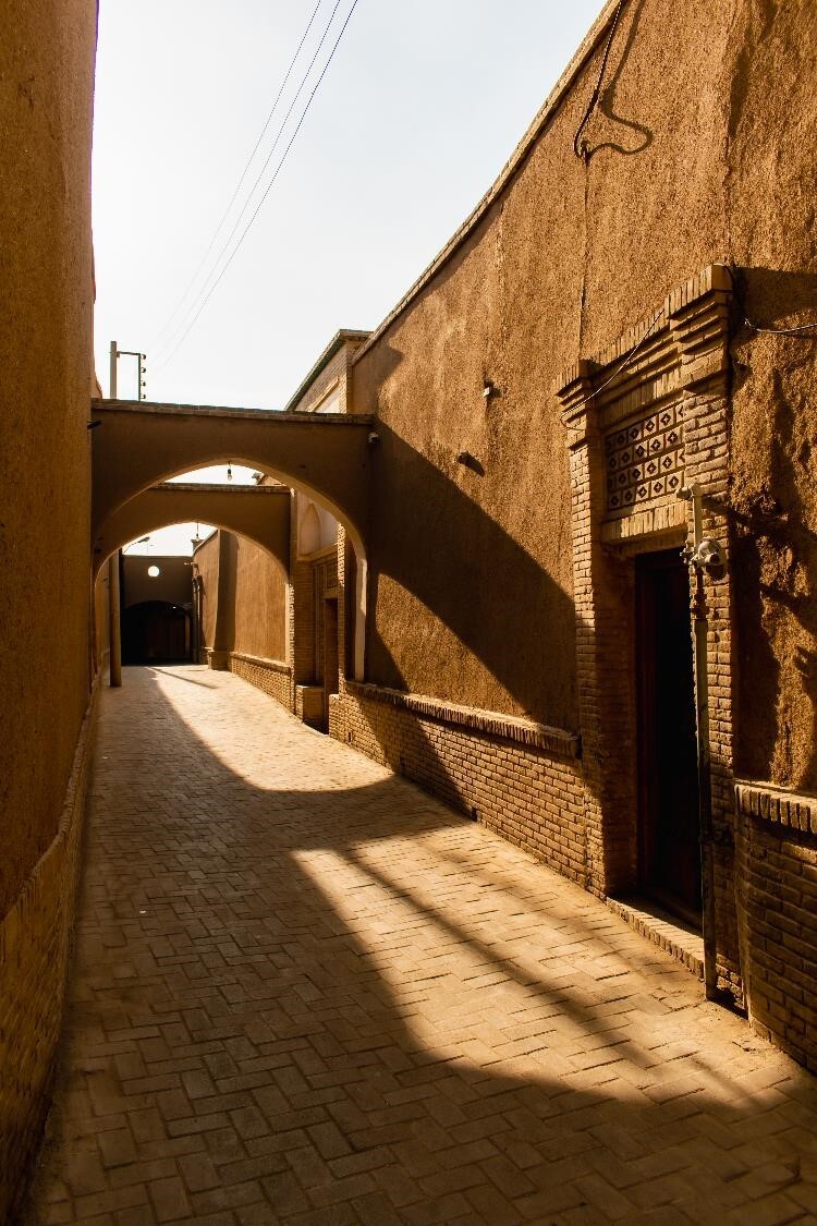 Mudbrick walls, arched beams, sunset shadows: Kashani alley, a timeless beauty