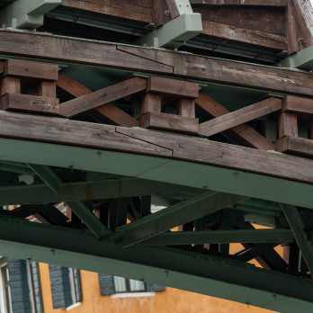 A view of the green metal truss and wooden elements of the Ponte dell'Accademia bridge
