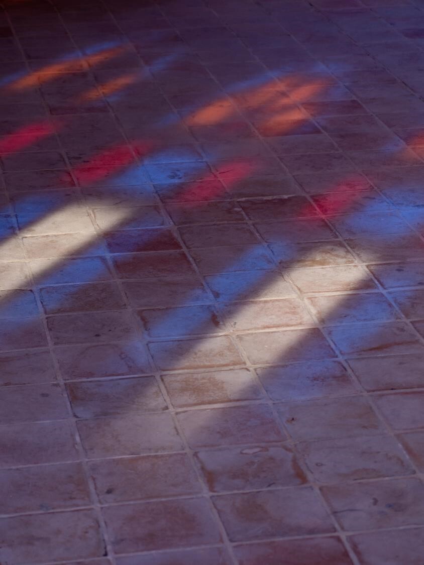 The stained glass farewell captures the sunlight as it dances on the traditional tiles of Kashan