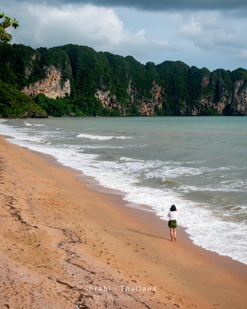 A lone woman walking along Ao Nang Beach in Krabi, Thailand