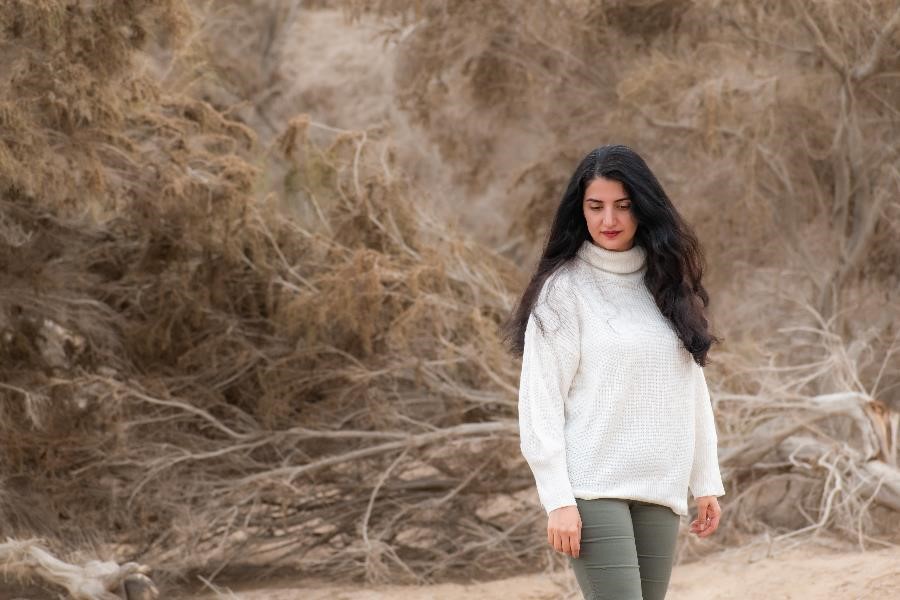 A Persian woman among the thick and dry branches of a native plant in Maranjab desert