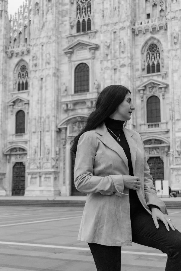 A Persian woman in classical dress standing in front of the Duomo in Milan